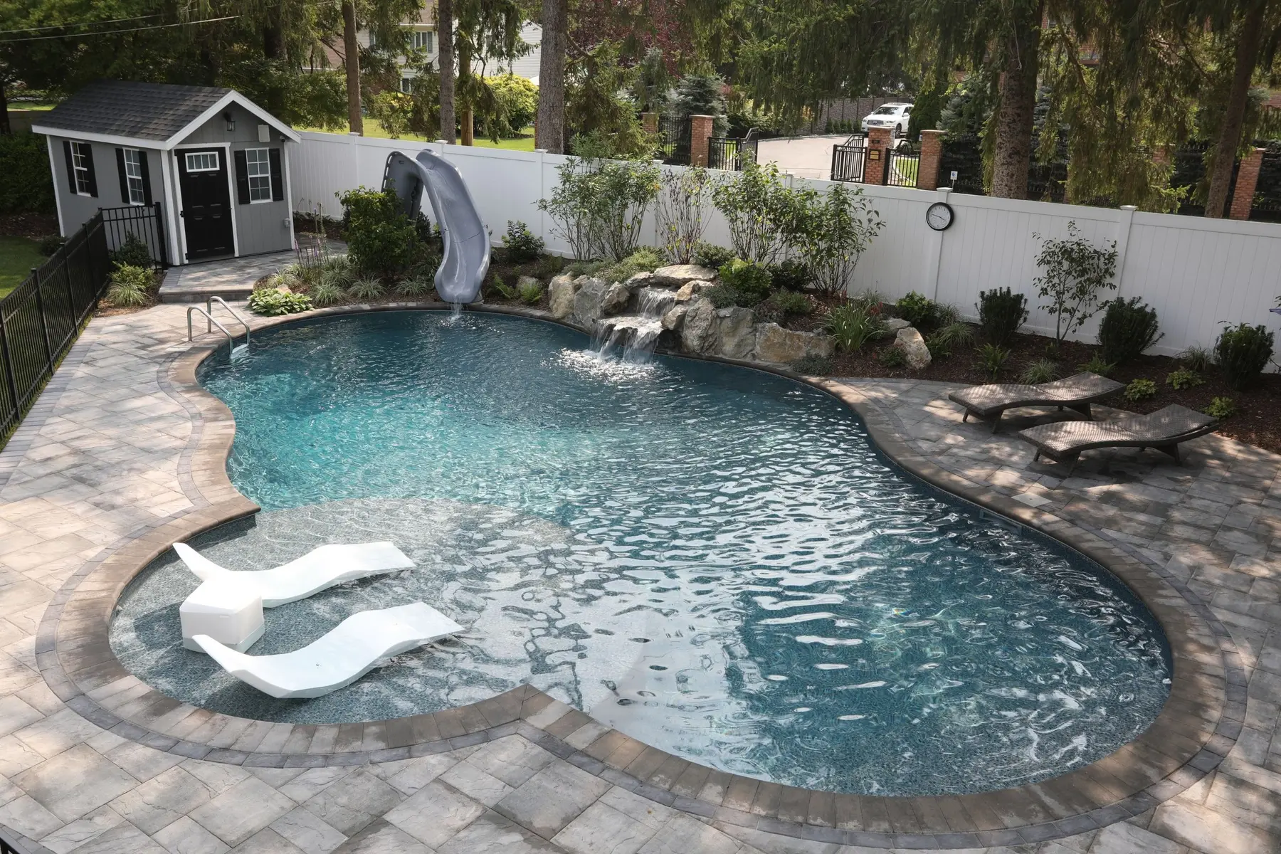 Backyard pool with waterfall and slide by Swim King